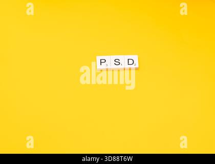 Les tuiles Scrabble épellent PSD sur un fond jaune. Banque D'Images