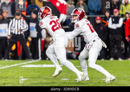 West Lafayette, Indiana, États-Unis. 28 novembre 2025. Le quarterback de l'Indiana Alberto Mendoza (16 ans) remet le bal au Running back de l'Indiana Khobie Martin (28 ans) lors d'un match de football NCAA entre les Hoosiers de l'Indiana et les Purdue Boilermakers au Ross-Ade Stadium à West Lafayette, Indiana. John Mersits/CSM/Alamy Live News Banque D'Images