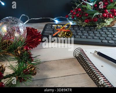 Bureau de vacances : clavier, décor, ordinateur portable - installation de bureau confortable fusionnant l'esprit de vacances avec la productivité, avec des décorations de Noël, clavier, noteboo Banque D'Images