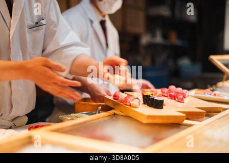 Les chefs préparent des sushis pour les clients dans un restaurant Banque D'Images