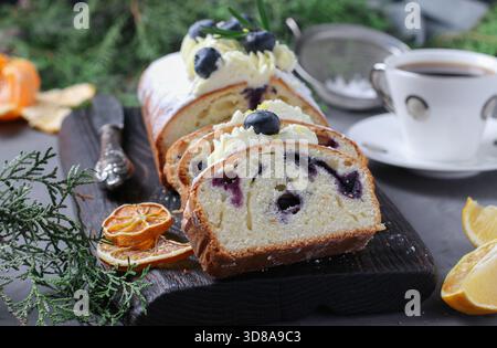 Gâteau citron-myrtille maison, saupoudré de sucre en poudre et décoré de crème éponge, coupé en portions Banque D'Images