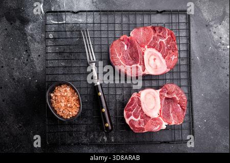 Jarret de veau cru frais ossobuco Premium, idéal pour la cuisson lente et la création de repas copieux et réconfortants qui impressionnent. fond noir. vue de dessus. Banque D'Images