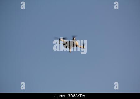 Quadrocoptère avec une caméra professionnelle vole dans le ciel bleu clair. Dron dans le ciel numérique avec vue sur la ville. Observation d'en haut Banque D'Images