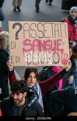 Rome, Italie. 29 novembre 2025. Un manifestant tient une pancarte qui indique "assoiffé de sang et d'argent" lors d'une manifestation contre l'économie de guerre et en soutien à la Palestine à Rome le 29 novembre 2025. Les manifestants demandent au gouvernement italien de cesser de fournir des armes à Israël. Participe à une manifestation contre l'économie de guerre et en soutien à la Palestine à Rome le 29 novembre 2025. Les manifestants demandent au gouvernement italien de cesser de fournir des armes à Israël. Crédit : Insidefoto/Alamy Live News Banque D'Images
