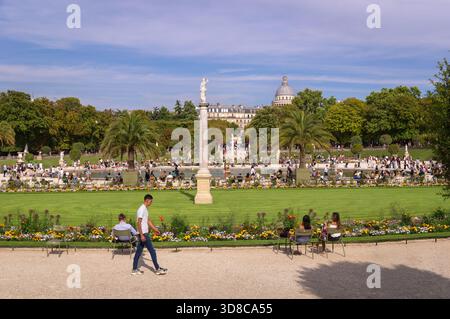 Paris, France 08 04 2025 : chaud après-midi d'été dans le jardin du Luxembourg avec des touristes se reposant et profitant du beau temps à côté des voili Banque D'Images