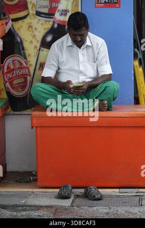 Little India, Singapour, 9 septembre 2025 un travailleur prend un congé pour rattraper Òsocial mediaÓ devant le village de GholiaÕs (anciennement le Tan T. Banque D'Images