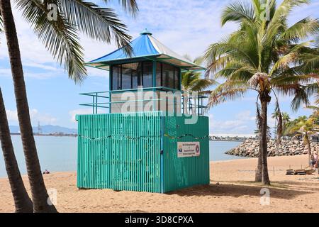 Townsville, Queensland, Australie - 24 juillet 2025 : tour de sauveteur turquoise entourée de palmiers sur une plage de sable du Strand Banque D'Images