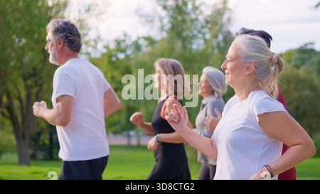 Amis sportifs seniors qui font du jogging ensemble dans un parc Banque D'Images