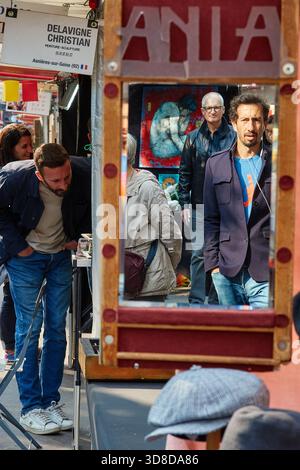 Paris, France - juin 2025 : les visiteurs parcourent le marché Edgar Quinet à Montparnasse, Paris, avec divers stands et un miroir réfléchissant. Le live Banque D'Images