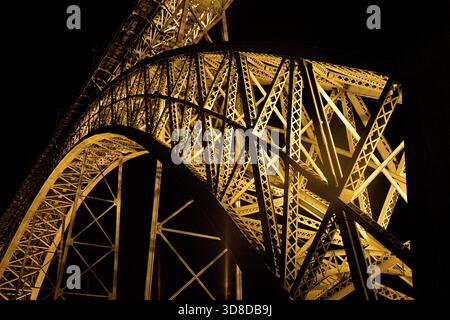 Les détails complexes d'un pont en acier Dom Luis I à Porto mettent en valeur son design architectural, illuminé dans un ciel nocturne Banque D'Images