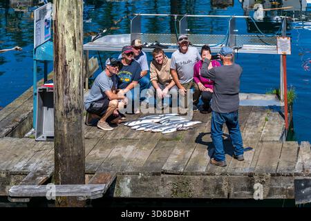 Pêcheurs et leurs prises du jour avec saumon sockeye et coho, marina Telegraph Cove, île de Vancouver, Colombie-Britannique, Canada. Banque D'Images