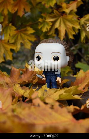 Funko Pop figurine d'action du tueur en série Michael Myers du film d'horreur Halloween. Feuillage orange d'automne, feuilles tombées reposent sur des planches de bois. Banque D'Images