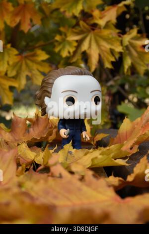 Funko Pop figurine d'action du tueur en série Michael Myers du film d'horreur Halloween. Feuillage orange d'automne, feuilles tombées reposent sur des planches de bois. Banque D'Images