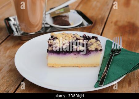 cheesecake aux myrtilles sur une plaque blanche sur une table en bois Banque D'Images