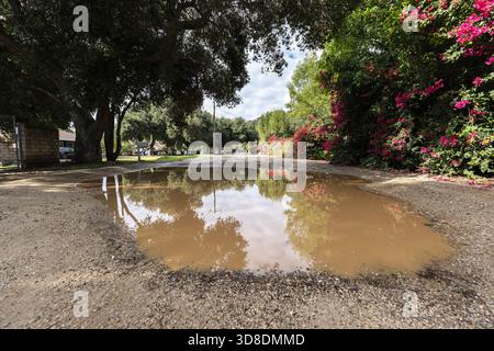 Flaque de boue sur un chemin de terre rural dans la banlieue de Chatsworth en Californie. Banque D'Images