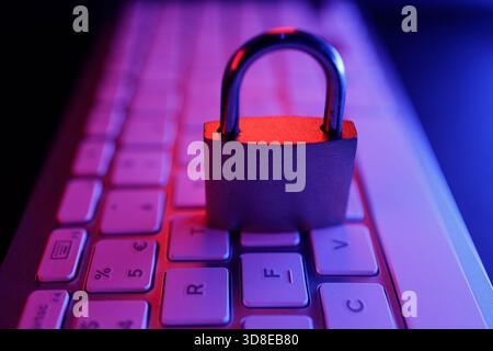 Un cadenas en métal repose en toute sécurité sur un clavier d'ordinateur, soulignant l'importance de la cybersécurité et de la protection Internet dans nos vies numériques. Le Banque D'Images