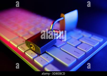 Un cadenas métallique repose sur un clavier d'ordinateur, symbolisant la sécurité et la protection d'Internet. Banque D'Images