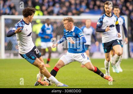 Govan, Écosse. 30 novembre 2025. Connor Barron du Rangers FC réussit à obtenir le ballon devant Filip Lissah du Falkirk FC lors de la William Hill SPFL premier Division, Rangers FC vs Falkirk FC crédit : Colin Poultney/Alamy Live News Banque D'Images