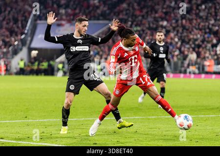 MUNICH, ALLEMAGNE - NOVEMBRE 29 : Michael Olise (FC Bayern Munich, 17) contrôle le ballon contre Mathias Pereira Lage (FC Pauli Hamburg, 28) lors du match de Bundesliga [Bundesliga] entre FC Bayern Munich vs FC Pauli Hamburg à Allianz Arena Banque D'Images