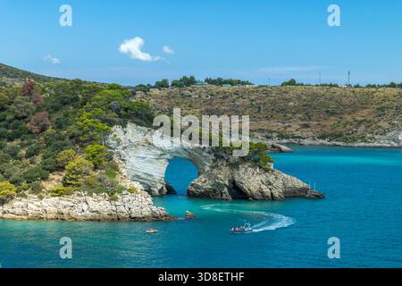 Arco di San Felice arc naturel encadrant la mer Adriatique turquoise avec des bateaux de croisière Banque D'Images