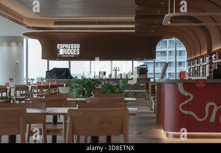Bangkok, Thaïlande - 18 octobre 2025 - le design contemporain rencontre les vues urbaines dans ce café moderne, avec des éléments en bois gracieux et courbés et un grand vent Banque D'Images