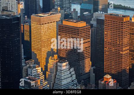 La dernière lumière chaude de l'après-midi brille sur East Midtown Manhattan, illuminant les gratte-ciels tandis que les ombres s'étendent sur les rues animées en contrebas. Banque D'Images