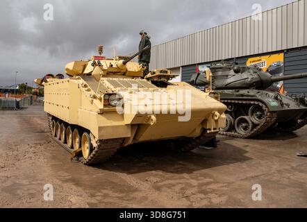Desert tan Warrior véhicule de combat d'infanterie exposé à l'extérieur au musée du réservoir de Bovington Dorset avec un autre réservoir historique en arrière-plan Banque D'Images