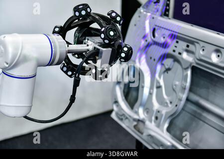Le scanner 3D sur bras robotisé mesure la précision des grandes pièces automobiles. dans les installations industrielles Banque D'Images