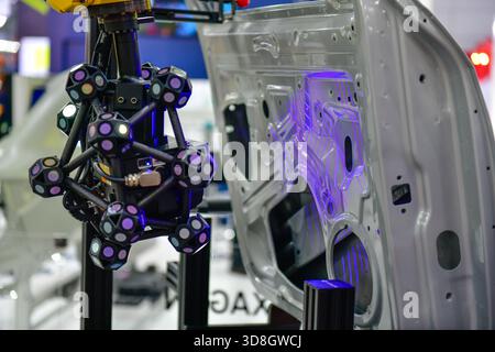 Le scanner 3D sur bras robotisé mesure la précision des grandes pièces automobiles. dans les installations industrielles Banque D'Images