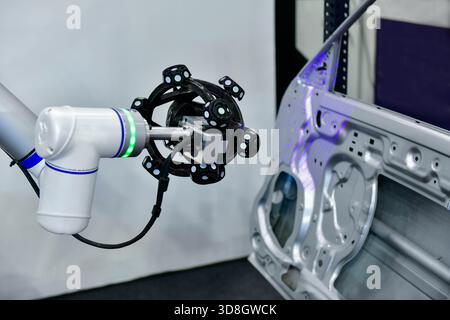 Le scanner 3D sur bras robotisé mesure la précision des grandes pièces automobiles. dans les installations industrielles Banque D'Images