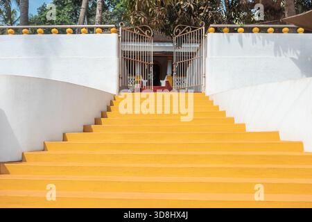 Un large escalier en pierre aux murs blancs mène à la maison avec jardin. Escaliers jaunes dans un style classique à la villa. Architecte minimaliste abstrait Banque D'Images