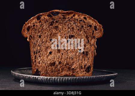 Panettone gâteau italien de Noël, pain doux traditionnel sucré avec des noix, des raisins secs et du chocolat dans une assiette rustique avec photographie alimentaire de décoration de sucre Banque D'Images