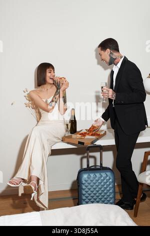 Couple aimant apprécie un délicieux repas dans leur hôtel, célébrant leur lien et leur bonheur. Banque D'Images