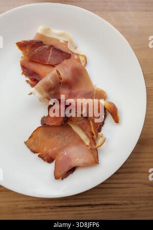 Prosciutto tranché sur une assiette blanche Banque D'Images