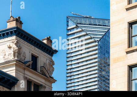 Montréal, Canada - 11 août 2025 : contraste entre gratte-ciel en verre moderne et architecture historique au centre-ville de Montréal Banque D'Images