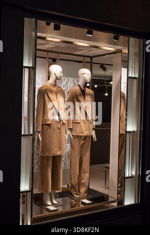 Une vitrine de magasin de haute couture avec deux mannequins en costumes chameau sur mesure. Vitrine illuminée, photo de nuit, personne Banque D'Images