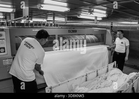 Photo du fichier : en mer. 01 décembre 2025. Ouvriers philippins dans la blanchisserie d'un bateau de croisière (noir et blanc). Aujourd'hui marque le premier jour du mois des Philippins d'outre-mer, une célébration nationale reconnaissant la diaspora philippine dans le monde entier, les travailleurs philippins d'outre-mer (OFW) et les familles vivant à l'étranger. L'initiative met en lumière leurs contributions économiques, sociales et culturelles, les envois de fonds aux Philippines, les défis migratoires, la résilience et le travail quotidien des Philippins travaillant loin de chez eux, reconnus par le Département des travailleurs migrants (DMW) comme les nouveaux héros du monde. Crédit : Kevin Izorce/Alamy Live News Banque D'Images