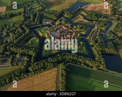 Vue aérienne des robustes terrassements et douves du fort étoilé embrassent le village pittoresque, une tapisserie de toits en terre cuite et d'arbres verdoyants, Bourtange, Gro Banque D'Images
