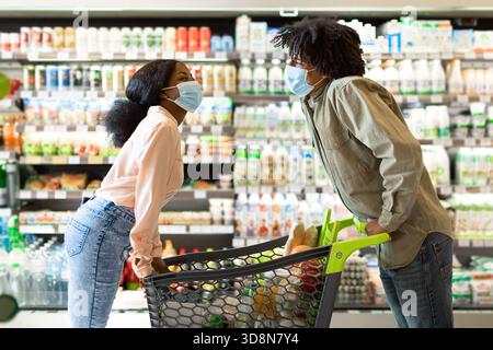 Couple aime magasiner ensemble dans l'épicerie tout en gardant la sécurité à l'esprit pendant la pandémie Banque D'Images