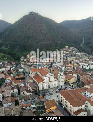 Vue aérienne des toits en terre cuite en cascade autour de la Chiesa Madre di San Michele Arcangelo sur fond de montagne spectaculaire, Volturara Irpina, Banque D'Images