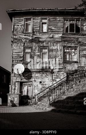 Photographie en noir et blanc d'une vieille maison en bois de l'époque ottomane à Amasra, présentant des murs en bois altérés, des fondations en pierre. Banque D'Images