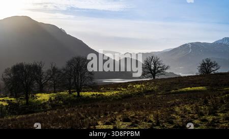 Lumière hivernale atmosphérique au-dessus d'Ullswater et des sommets environnants. Banque D'Images