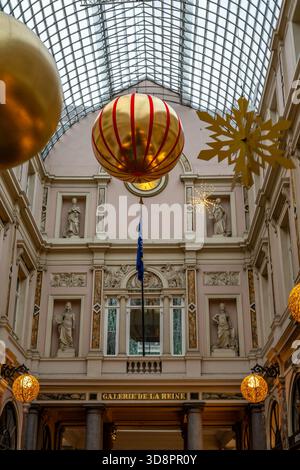 Bruxelles, Belgique - 30 novembre 2025 : décorations festives de Noël et lumières dorées décorant la Galerie de la Reine sous son emblématique toit en verre. Banque D'Images