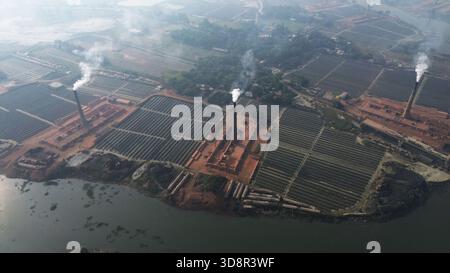 Dhaka, Wari, Bangladesh. 1er décembre 2025. De la fumée s'échappe des cheminées d'une usine de briques à la périphérie de Dhaka, au Bangladesh, le 2 décembre 2025. Ces usines de briques contribuent à la forte pollution atmosphérique au Bangladesh. L'indice de la qualité de l'air et de la vie (AQLI) classe le Bangladesh parmi les pays les plus pollués au monde. Selon l’Organisation mondiale de la santé (OMS), la pollution atmosphérique est responsable de la mort d’environ sept millions de personnes dans le monde chaque année, le 02 décembre. 2025, (crédit image : © Habibur Rahman/ZUMA Press Wire) USAGE ÉDITORIAL SEULEMENT ! Pas pour Commerc Banque D'Images