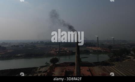 Dhaka, Wari, Bangladesh. 1er décembre 2025. De la fumée s'échappe des cheminées d'une usine de briques à la périphérie de Dhaka, au Bangladesh, le 2 décembre 2025. Ces usines de briques contribuent à la forte pollution atmosphérique au Bangladesh. L'indice de la qualité de l'air et de la vie (AQLI) classe le Bangladesh parmi les pays les plus pollués au monde. Selon l’Organisation mondiale de la santé (OMS), la pollution atmosphérique est responsable de la mort d’environ sept millions de personnes dans le monde chaque année, le 02 décembre. 2025, (crédit image : © Habibur Rahman/ZUMA Press Wire) USAGE ÉDITORIAL SEULEMENT ! Pas pour Commerc Banque D'Images
