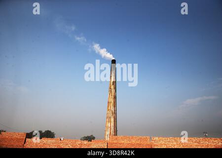 Dhaka, Wari, Bangladesh. 1er décembre 2025. De la fumée s'échappe des cheminées d'une usine de briques à la périphérie de Dhaka, au Bangladesh, le 2 décembre 2025. Ces usines de briques contribuent à la forte pollution atmosphérique au Bangladesh. L'indice de la qualité de l'air et de la vie (AQLI) classe le Bangladesh parmi les pays les plus pollués au monde. Selon l’Organisation mondiale de la santé (OMS), la pollution atmosphérique est responsable de la mort d’environ sept millions de personnes dans le monde chaque année, le 02 décembre. 2025, (crédit image : © Habibur Rahman/ZUMA Press Wire) USAGE ÉDITORIAL SEULEMENT ! Pas pour Commerc Banque D'Images