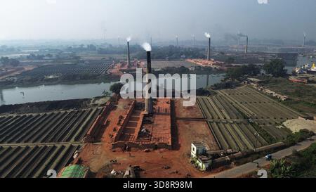 Dhaka, Bangladesh. 1er décembre 2025. De la fumée s'échappe des cheminées d'une usine de briques à la périphérie de Dhaka, au Bangladesh, le 2 décembre 2025. Ces usines de briques contribuent à la forte pollution atmosphérique au Bangladesh. L'indice de la qualité de l'air et de la vie (AQLI) classe le Bangladesh parmi les pays les plus pollués au monde. Selon l’Organisation mondiale de la santé (OMS), la pollution atmosphérique est responsable de la mort d’environ sept millions de personnes dans le monde chaque année, le 02 décembre. 2025, photo de Habibur Rahman/ABACAPRESS.COM crédit : Abaca Press/Alamy Live News Banque D'Images