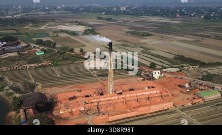 Dhaka, Bangladesh. 1er décembre 2025. De la fumée s'échappe des cheminées d'une usine de briques à la périphérie de Dhaka, au Bangladesh, le 2 décembre 2025. Ces usines de briques contribuent à la forte pollution atmosphérique au Bangladesh. L'indice de la qualité de l'air et de la vie (AQLI) classe le Bangladesh parmi les pays les plus pollués au monde. Selon l’Organisation mondiale de la santé (OMS), la pollution atmosphérique est responsable de la mort d’environ sept millions de personnes dans le monde chaque année, le 02 décembre. 2025, photo de Habibur Rahman/ABACAPRESS.COM crédit : Abaca Press/Alamy Live News Banque D'Images