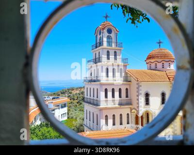 Vue unique sur le clocher du monastère de Saint Raphaël à travers un trou rond, île de Lesbos, Grèce. Banque D'Images