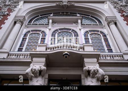 Vue rapprochée de la façade du Théâtre Sébastopol montrant des vitraux, des ornements architecturaux détaillés et deux figures masculines sculptées supportant Banque D'Images